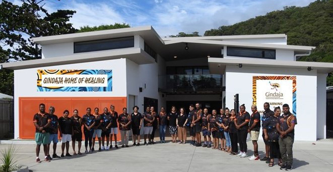 A large group of people posing in front of the Gindaja Learning and Wellbeing Centre.